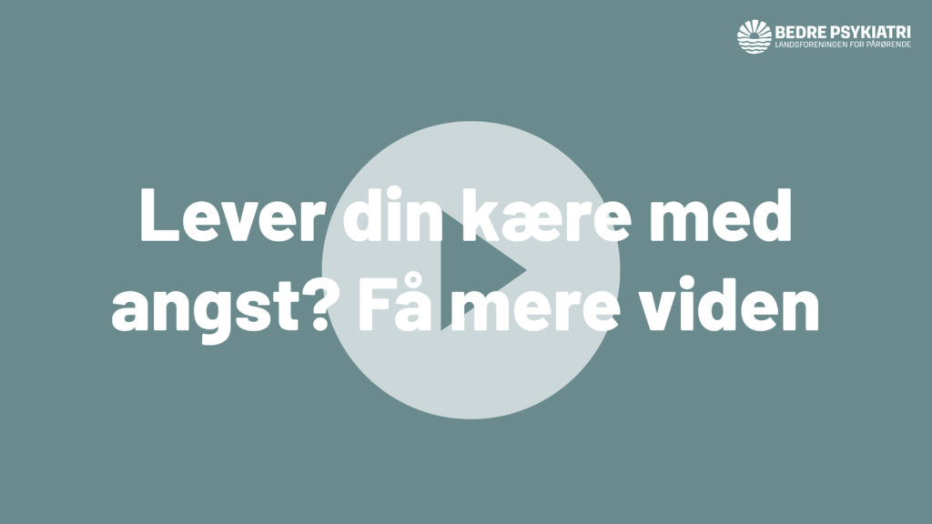 Tekst på blå baggrund: "Lever din kære med angst? Få mere vid..." med et play-ikon i midten.