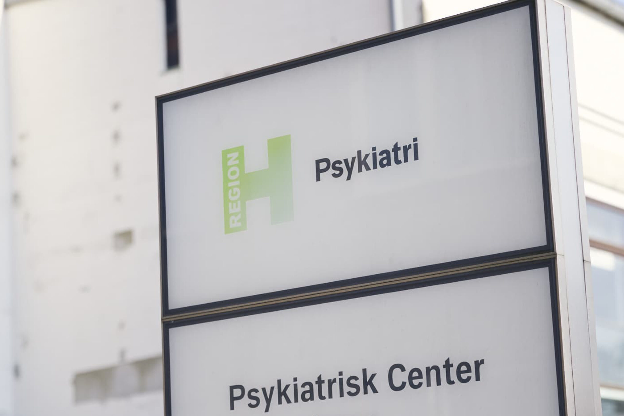 skilt foran en bygning viser teksten "Region H Psykiatri" og "Psykiatrisk Center".