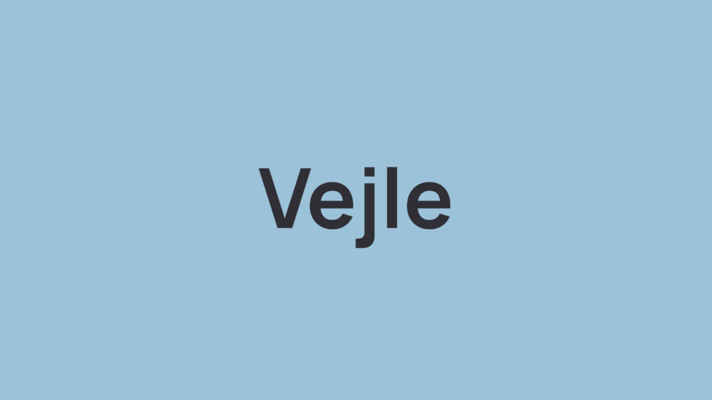 Sort tekst “Vejle” i sort skrift centreret på en lys blå baggrund.
