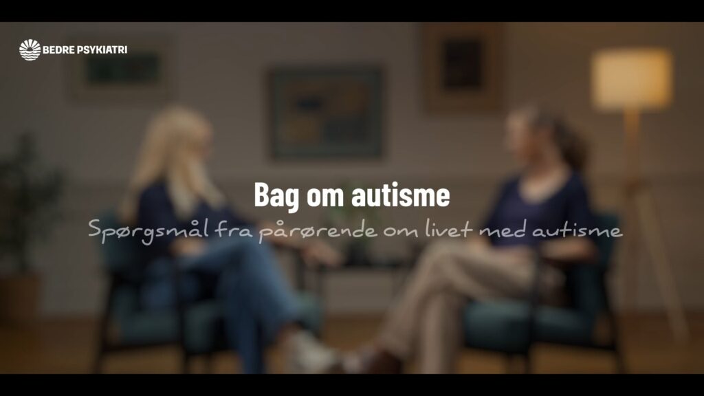 personer sidder overfor hinanden i en samtale, med teksten "Bag om autisme" og sløret baggrund af et hyggeligt rum.
